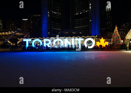TORONTO, KANADA - 2018-01-01: Leute, die sich vor Toronto mit Weihnachtsbaum in der Nacht über die Eislaufbahn auf dem zentralen Nathan P Stockfoto