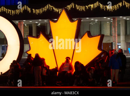 TORONTO, KANADA - 2018-01-01: torontonians vor der glühenden Maple Leaf, der kanadische Symbol, Rest nach Spaß auf der Eislaufbahn Stockfoto
