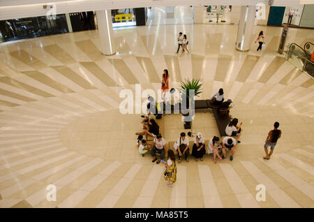 Menschen sitzen und am Treffpunkt warten und Menschen zu Fuß und mit Rolltreppe nach oben und unten für Shopping im Kaufhaus am 23. Mai 2017 Stockfoto