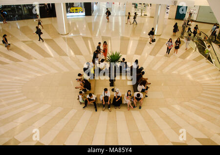 Menschen sitzen und am Treffpunkt warten und Menschen zu Fuß und mit Rolltreppe nach oben und unten für Shopping im Kaufhaus am 23. Mai 2017 Stockfoto