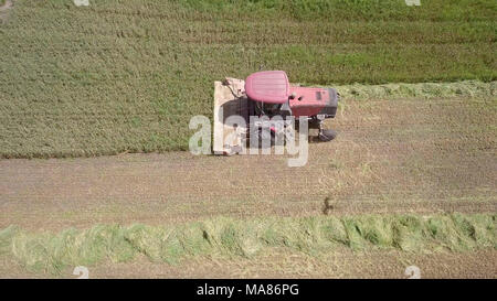 Luftaufnahmen von Red Harvest kombinieren ein grünes Weizenfeld Stockfoto