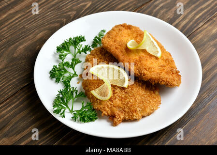 Lecker Hähnchen Schnitzel in der Platte auf hölzernen Tisch. Nähe zu sehen. Stockfoto