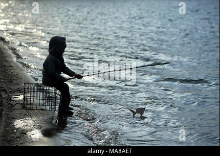 Ein fünf Jahre alter Junge ist das Angeln am See. Stockfoto