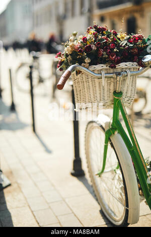 Retro Fahrrad mit Strauß Blumen stehen auf der Straße Stockfoto