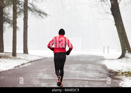Alter Mann runner läuft durch Winter Forest der Park von Monza, Italien Stockfoto