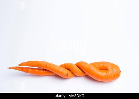Karotten der ungewöhnlichen Form liegt auf einem weißen Hintergrund Stockfoto