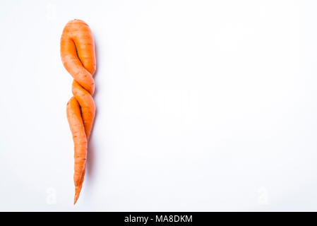 Karotten der ungewöhnlichen Form liegt auf einem weißen Hintergrund Stockfoto