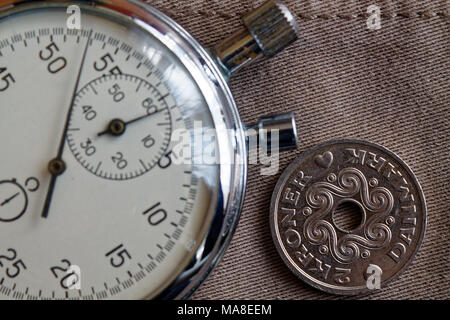 Dänemark Münze mit einer Stückelung von zwei Krone (Crown), und die Stoppuhr auf beige denim Hintergrund - Hintergrund Stockfoto