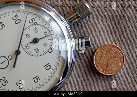 Euro Münze mit einer Stückelung von 1 Euro Cent und die Stoppuhr auf abgenutzten beige denim Hintergrund - Hintergrund Stockfoto