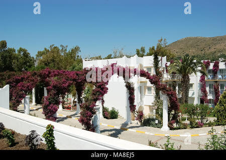 Turgutreis, Türkei - Juni 1, 2009: Weiße Villen und Bögen des violetten Blüten auf dem Gebiet der Hotel Kadikale Resort. Stockfoto