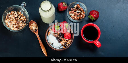 Gesundes Frühstück. Müsli mit Erdbeeren, Honig, Nüsse, Tasse starken Kaffee, Obst. Konzept einer gesunden Ernährung. Ansicht von oben, kopieren Raum Stockfoto