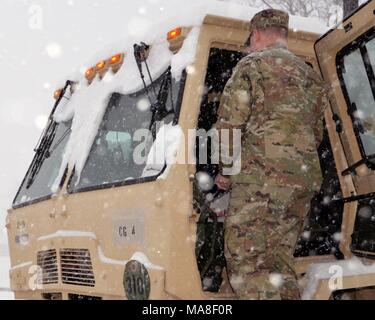 Ein New York Army National Guard Soldat aus der 42th Combat Aviation Brigade in Latham, NNEUE York bereitet seinen Träger für Missionen als massive snow Storm hits New York, 14. März 2017. () Stockfoto