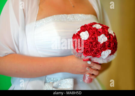 Braut Holding farbenfrohe künstliche Blumen Blumenstrauß mit ihren Händen am Hochzeitstag Stockfoto