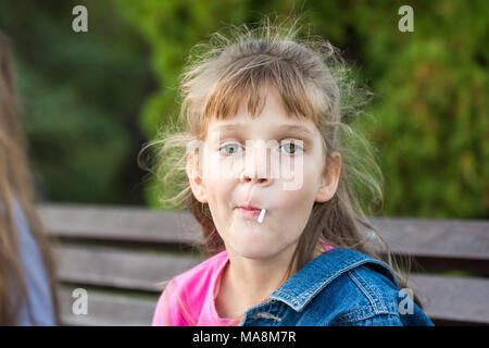 Porträt einer sechs-jährige Schwule Mädchen, saugt einen Lutscher Stockfoto