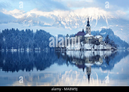 Panorama Winter Blick auf Schnee Bled Insel mit der Burg von Bled und die Berge im Hintergrund, Slowenien abgedeckt. Stockfoto