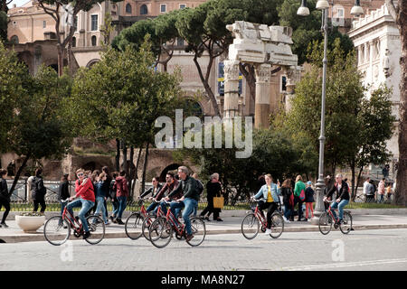 Das Forum Romanum und der Tempel der Venus Genetrix im Hintergrund einer Gruppe von Radfahrern auf die Via Dei Fori Imperiali, Rom Stockfoto
