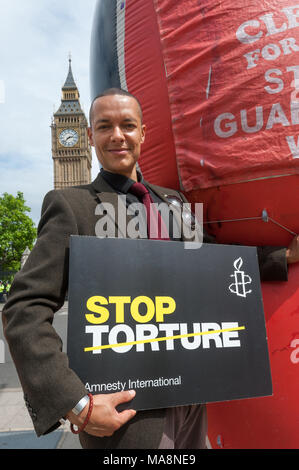 Clive Lewis, letzten Monat gewählt als Labour MP für Norwich Süden wirft mit einer Amnestie Poster top Folter" und einem riesigen aufblasbaren Shaker Aamer vor Big Ben. Stockfoto