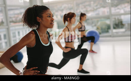 Gruppe von jungen Frauen trainieren im Fitnessstudio. Drei Frauen in einem Stretching Klasse im Health Club. Stockfoto