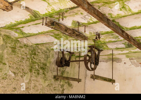 Abgebrochene Wassermühle. Rostige Räder und grünem Moos bedeckt die alte Mauer, natürlichen Hintergrund Stockfoto