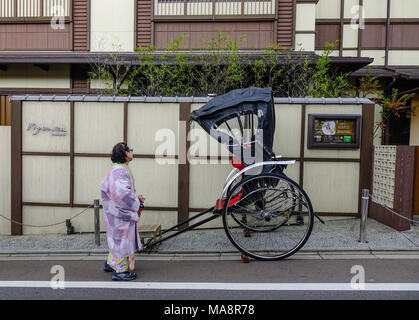 Kyoto, Japan - 29.November 2016. Eine Frau mit der Rikscha auf der Straße an der alten Stadt in Kyoto, Japan. Kyoto war die Hauptstadt von Japan seit mehr als einem Jahrtausend. Stockfoto