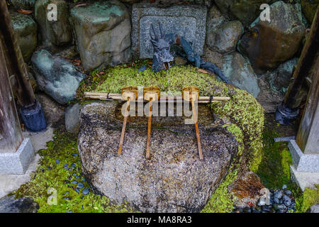 Japanischer Holz- Pfannen bei Shinto Tempel in Kyoto, Japan. In Japan ein tsukubai ist ein Waschbecken am Eingang zu den heiligen Stätten für die Besucher pur zur Verfügung gestellt Stockfoto