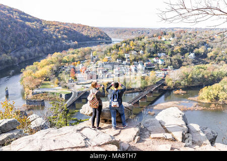 Harper's Ferry, USA - November 11, 2017: Blicken Sie mit Wanderer Leute, paar Frauen, bunte orange gelb Laub Herbst Herbst Wald mit kleinen Villag Stockfoto