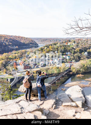 Harper's Ferry, USA - November 11, 2017: Blicken Sie mit Wanderer Leute, paar Frauen, bunte orange gelb Laub Herbst Herbst Wald mit kleinen Villag Stockfoto