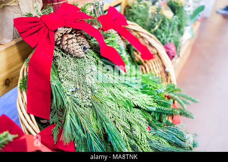 Green Pine needle red ribbon Mistel closeup im Korb auf dem Display in der Ferienzeit festliche Weihnachten store Shop, Wacholderbeeren, Tannenzapfen pinecon Stockfoto