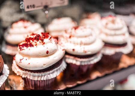 Makro Nahaufnahme von Red velvet Cupcakes in Bäckerei in muffin Papier Zylinderbüchsen mit white Cream Cheese frosting Vereisung Stockfoto