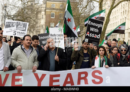 Syrische Demonstranten sind Plakate, während einer Demonstration gegen das Assad-regime außerhalb der Downing Street in London, UK. Stockfoto