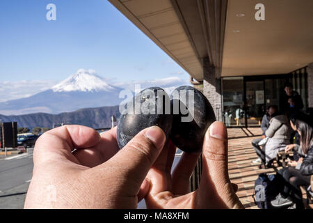 Schwarze Eier in den Schwefel der Berg Hakone gekocht und Owakudani-Bergen aufsteigenden Geschäfte mit Mount Fuji verkauft im Hintergrund Stockfoto