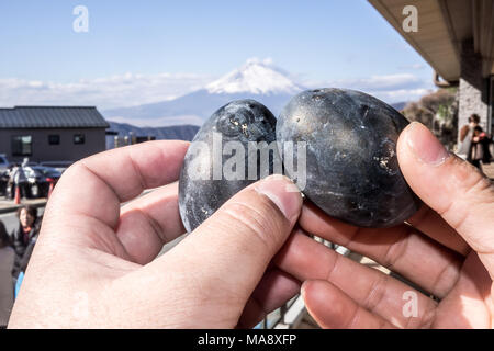 Schwarze Eier in den Schwefel der Berg Hakone gekocht und Owakudani-Bergen aufsteigenden Geschäfte mit Mount Fuji verkauft im Hintergrund Stockfoto