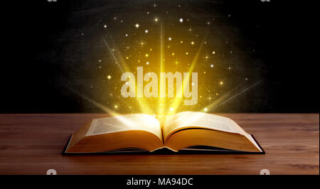 Gelbe Leuchten und Funkeln aus einem offenen Buch Stockfoto