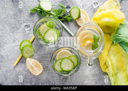 Zitrusfrüchte und Kräutern infundiert Sassi Wasser für Detox, gesundes Essen in Gläsern und Kanne auf über dunklen Hintergrund Stockfoto