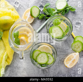 Zitrusfrüchte und Kräutern infundiert Sassi Wasser für Detox, gesundes Essen in Gläsern und Kanne auf über dunklen Hintergrund Stockfoto