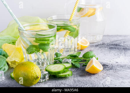 Zitrusfrüchte und Kräutern infundiert Sassi Wasser für Detox, gesundes Essen in Gläsern und Kanne auf über dunklen Hintergrund Stockfoto