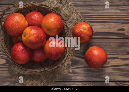 Blut orange Frucht in einem Weidenkorb auf dunklen Holztisch. Stockfoto