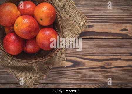 Blut orange Frucht in einem Weidenkorb auf dunklen Holztisch. Stockfoto