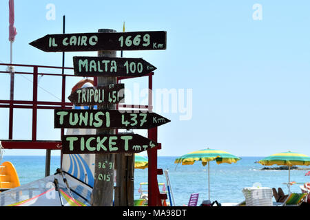 Multidirektionale Schild mit Kilometerstand in ferne Städte und Ticket Office Stockfoto