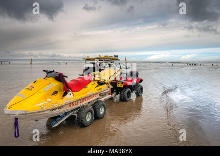 Ein rnli Beach Patrol Fahrzeug wacht auf die Surfer an Saunton Sands in North Devon an einem bewölkten Ostern Karfreitag im Südwesten von England Stockfoto