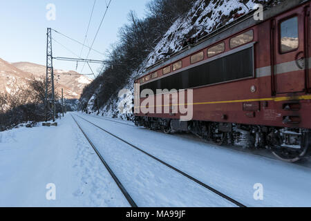 Rote elektrische Lokomotive Lokomotive Bewegen im Schnee Schienen in Bulgarien im Winter Stockfoto