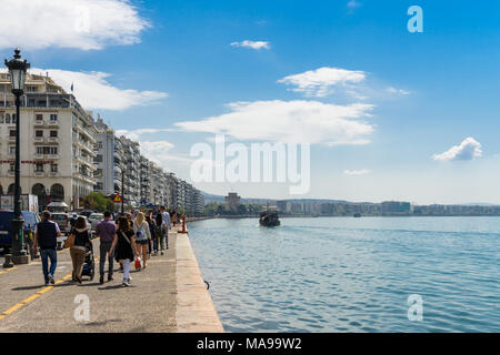 Thessaloniki, Griechenland - 14. April 2017: Menschen zu Fuß an der Strandpromenade in den Nachmittag mit einem Rundgang bot im Ägäischen Meer und den Weißen Turm in Stockfoto