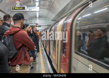 Die Menschen warten auf einen Zug, der nur in einem Londoner U-Bahnhof angekommen ist. Stockfoto