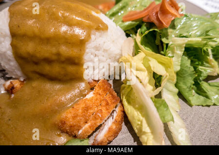 Nahaufnahme des Huhns Katsu Curry mit Reis und Salat serviert. Stockfoto