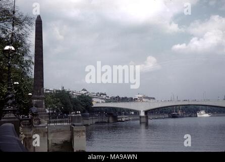 Blick auf die Innenstadt von London, England an einem bewölkten und bewölkten Tag, mit der Themse und Waterloo Bridge sichtbar und Cleopatra's Needle, ein ägyptischer Obelisk, im Vordergrund, 1955. () Stockfoto