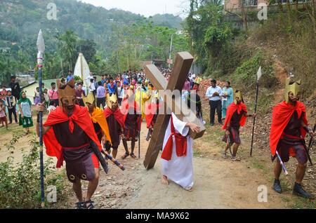 Karfreitagsprozession, Guwahati, Assam, Indien. Am 30. März 2018. Ein Devotee gekleidet, wie Jesus Christus re-inszeniert die Kreuzigung während der Karfreitagsprozession in Guwahati. Stockfoto