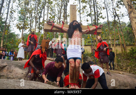 Karfreitagsprozession, Guwahati, Assam, Indien. Am 30. März 2018. Ein Devotee gekleidet, wie Jesus Christus re-inszeniert die Kreuzigung während der Karfreitagsprozession in Guwahati. Stockfoto