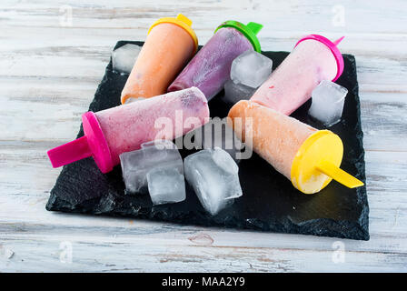 Hausgemachte Eiscreme von Beeren. Kalten Sommer Dessert aus gefrorenen Aprikosenpülpe, Pfirsiche, Johannisbeeren, Erdbeeren, Blaubeeren mit Eis auf schwarze Platte auf Stockfoto