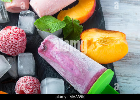 Hausgemachte Eiscreme von Beeren. Kalten Sommer Dessert aus gefrorenen Aprikosenpülpe, Pfirsiche, Johannisbeeren, Erdbeeren, Blaubeeren mit Eis und Früchte auf bla Stockfoto
