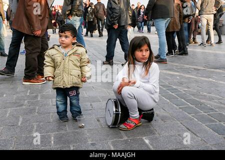 Junge und ein Mädchen, Musik zu spielen, und Sie verdienen sich einige Münzen vor dem überfüllten Platz, Istanbul, Türkei, 12. November 2017. () Stockfoto